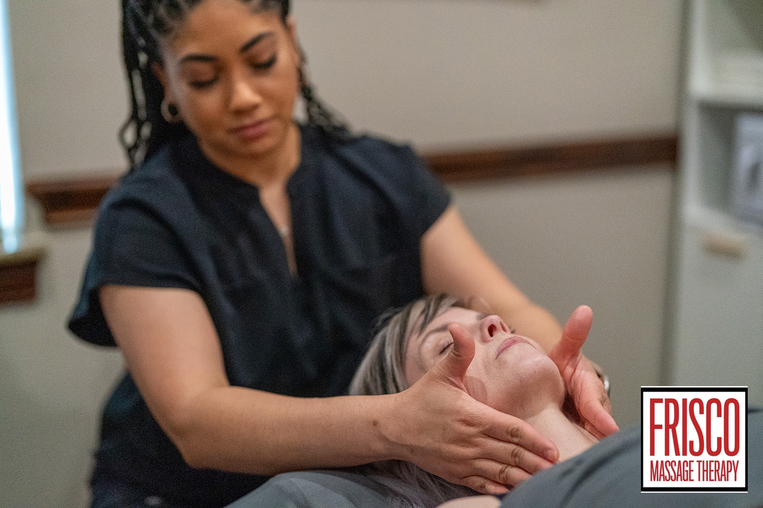 A massage therapist gives a client a neck massage in a treatment room, highlighting manual lymphatic drainage benefits. The "Frisco Massage Therapy" logo is visible in the lower right corner of the image.