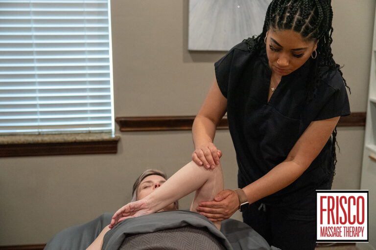 A massage therapist stretches a client’s arm during a session in a treatment room, demonstrating how therapeutic massage helps scar tissue heal and improve flexibility. The Frisco Massage Therapy logo is visible in the lower right corner.