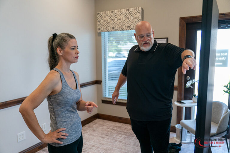 A man in a black polo shirt points toward a screen to help a woman in a gray tank top track body composition while on GLP-1 medication.
