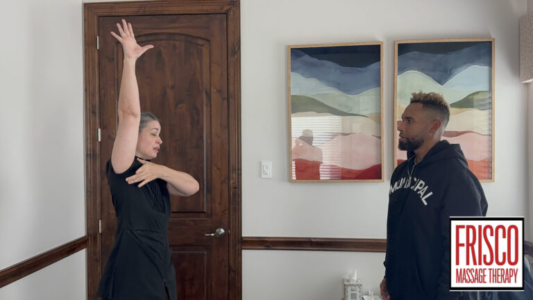 A woman demonstrates an arm stretch to a man in a room with abstract paintings and a wooden door, highlighting how therapeutic massage aids in post-surgery recovery. Frisco Massage Therapy logo bottom right.